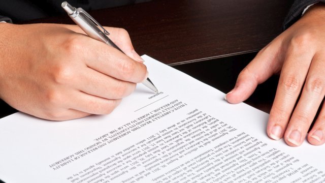 Businesswoman signing a document.